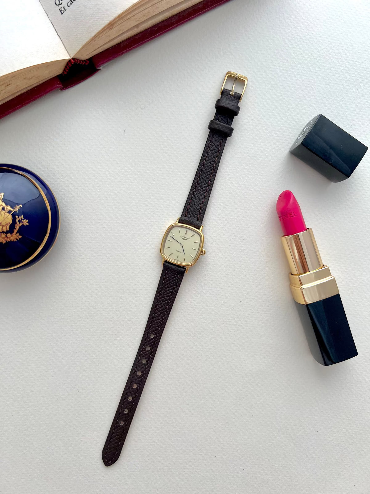 Longines Champagne Dial Gold Cushion Leather watch: watch arranged with styling props.