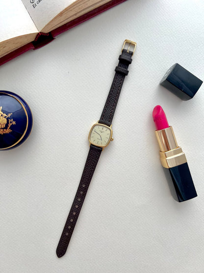 Longines Champagne Dial Gold Cushion Leather watch: watch arranged with styling props.