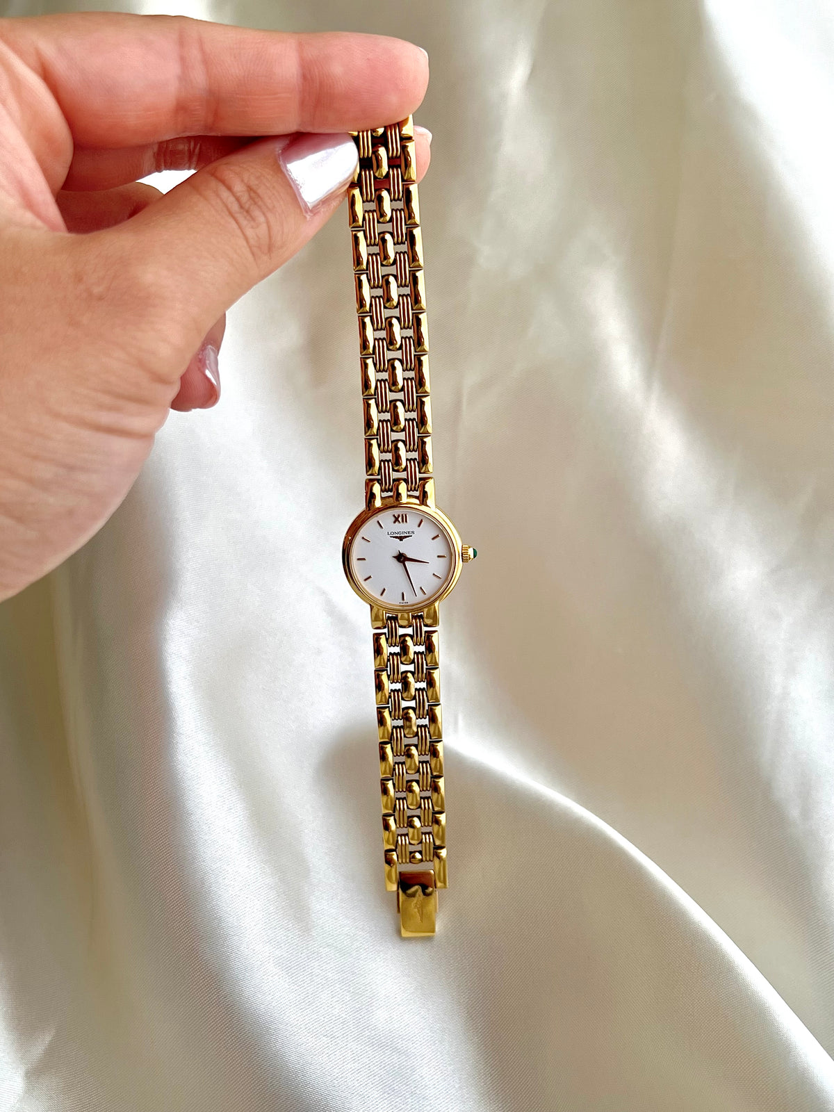 Longines Green Stone Crown Gold Bracelet watch L6.205.2: watch held to show its dial and bracelet.