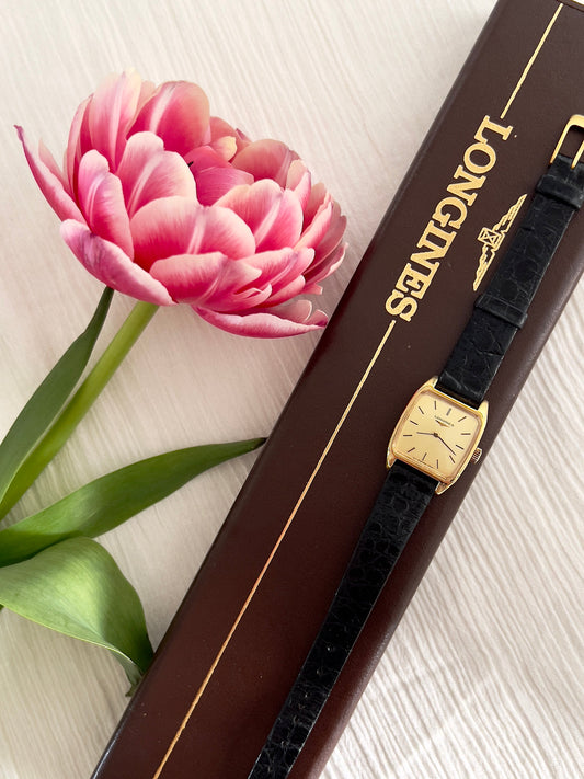 Vintage Longines gold-tone tonneau watch with gold dial and original black leather strap.