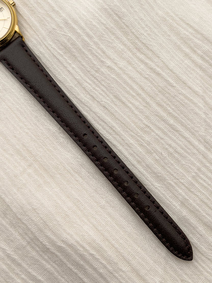Side profile of the Longines round case and gold-tone crown.
