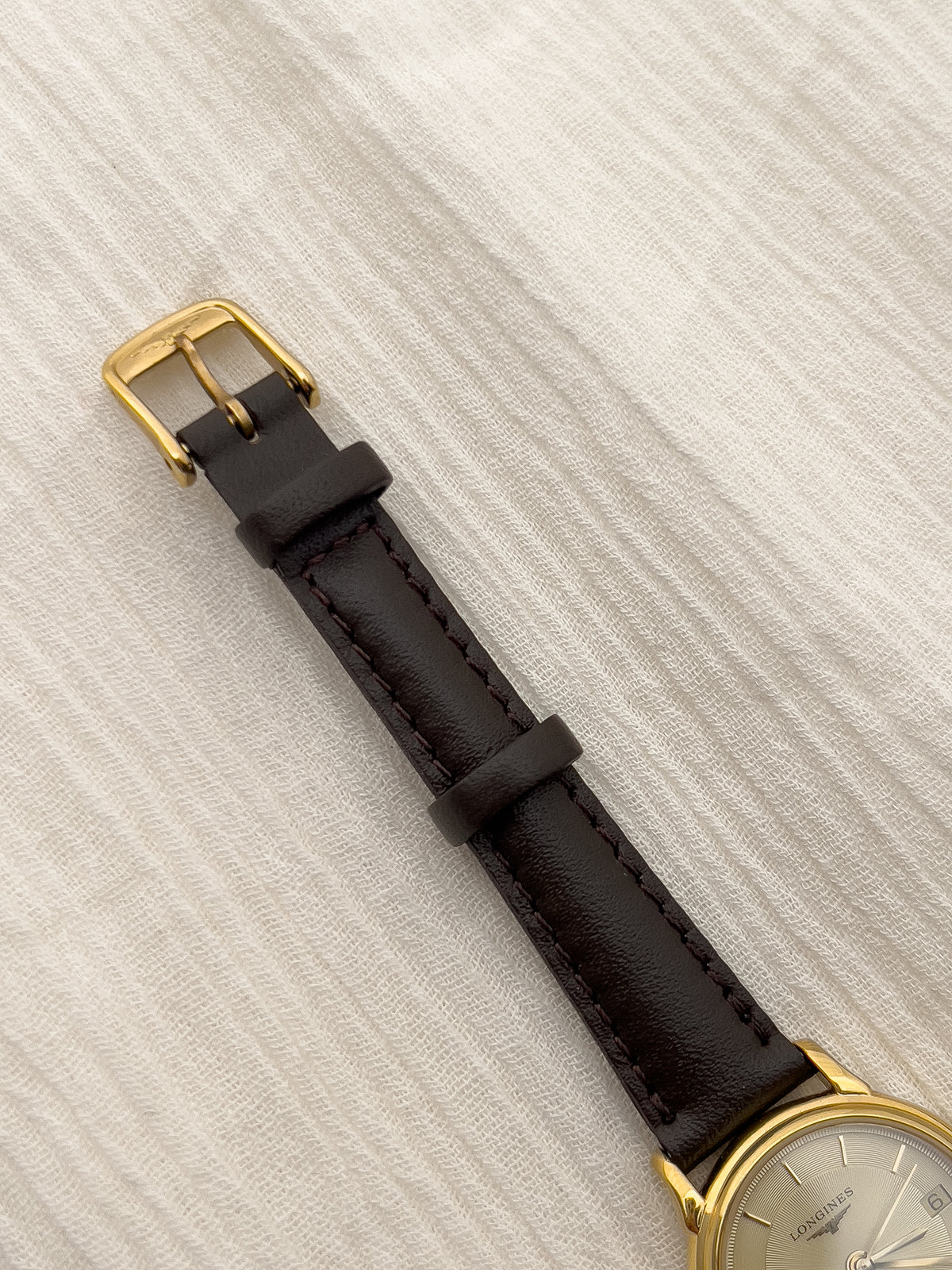 Detail of the aftermarket leather strap and original clasp on the Longines watch.