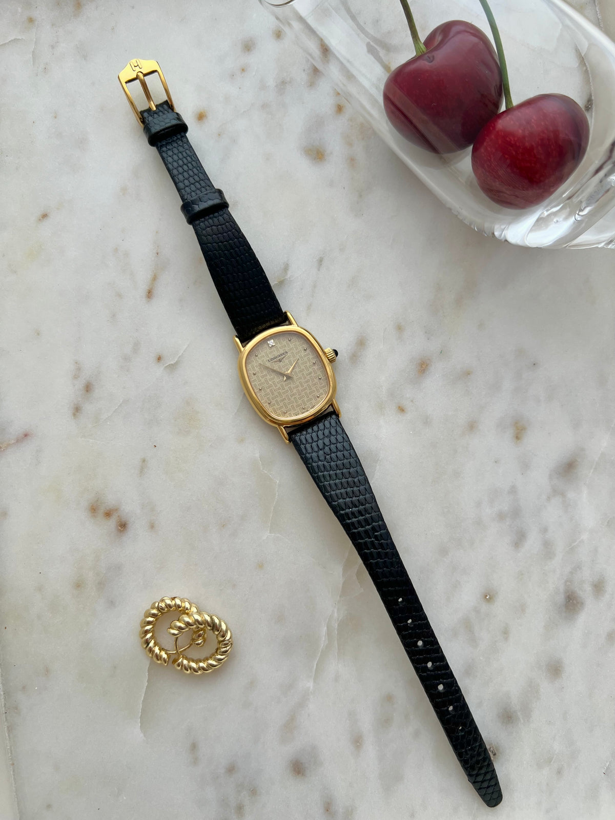 Longines Oblong Patterned Dial Women’s Watch — Full watch laid vertically beside cherries