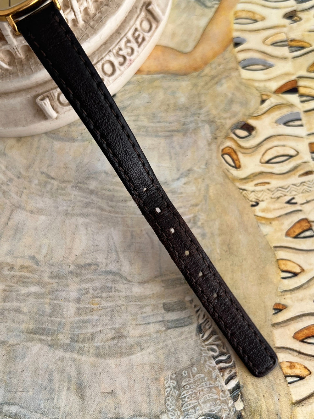 Original black leather Longines watch strap showing stitching, adjustment holes and existing wear
