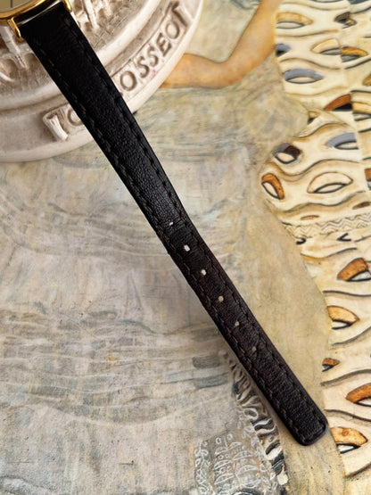 Original black leather Longines watch strap showing stitching, adjustment holes and existing wear