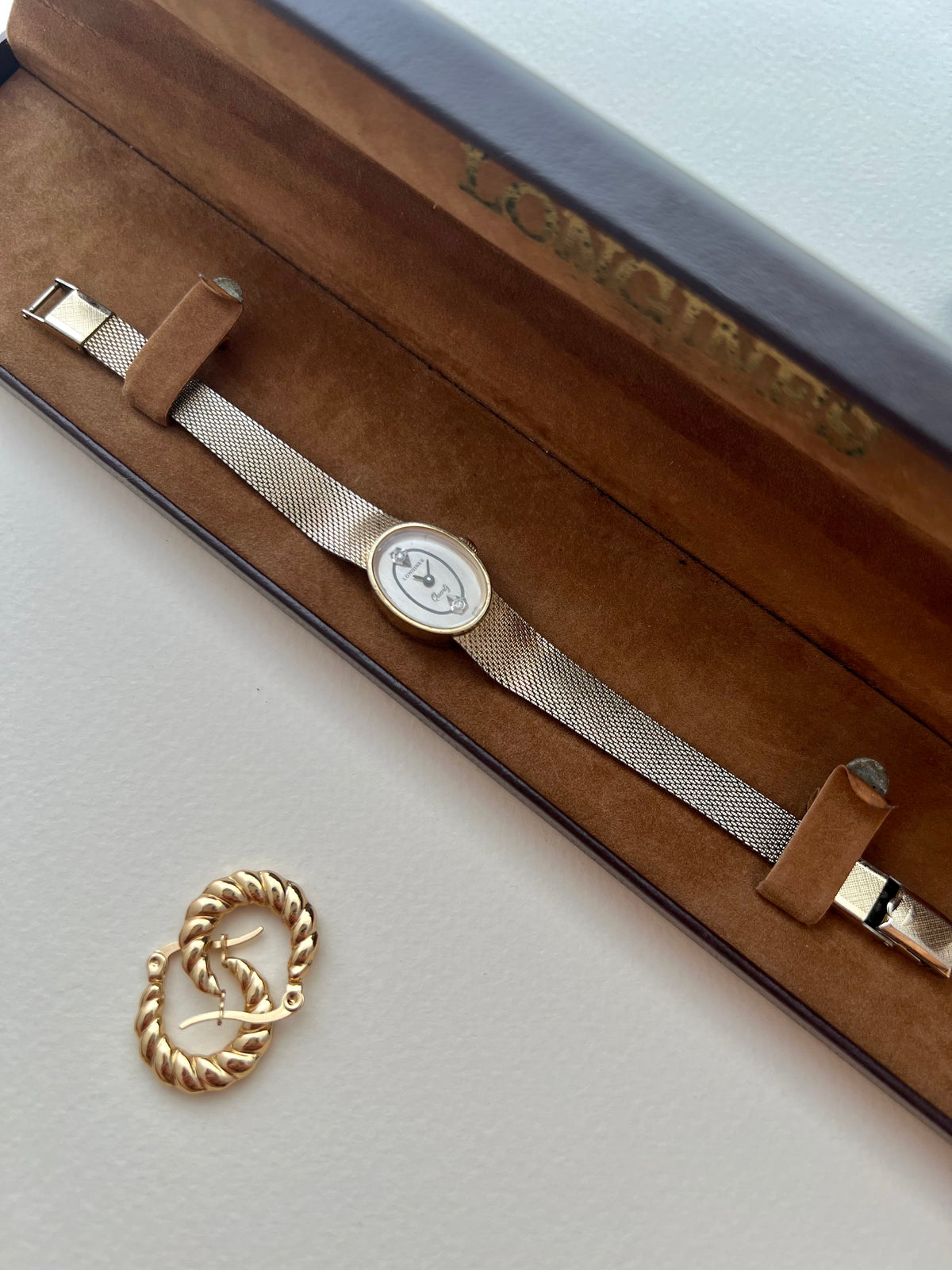 Detail of the Longines oval ivory dial with crystal markers and slim dark hands.