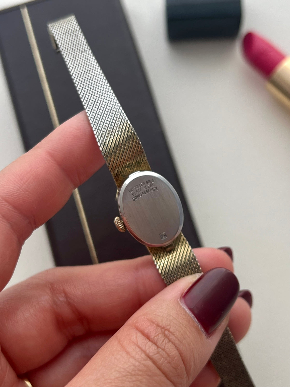 Front view of the Longines oval dial watch with crystal accents and gold-tone bracelet.
