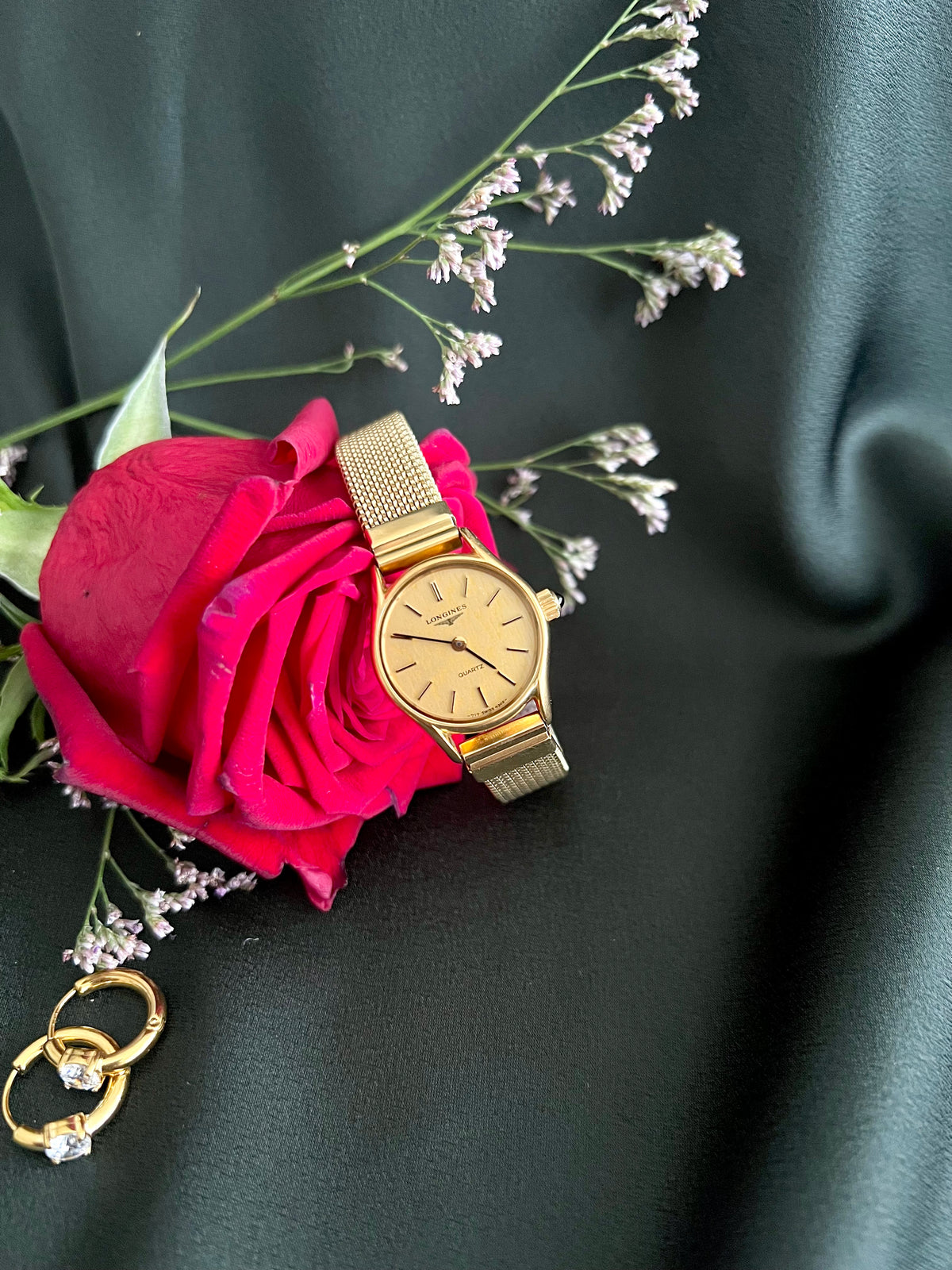 Longines Champagne Bracelet Women’s Watch — full expansion bracelet beside roses
