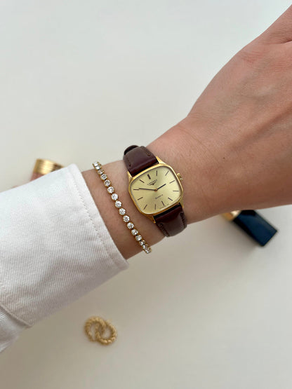 Front view of the Longines soft octagonal ladies watch with pale champagne dial and brown leather strap.