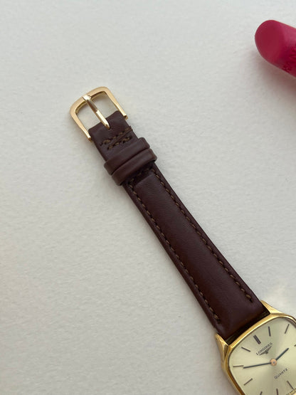 Full front view of the Longines soft octagonal watch with champagne dial and brown leather strap.