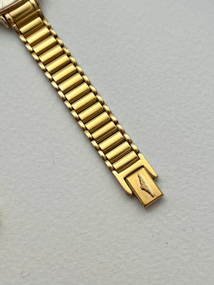 Vintage Longines gold bracelet watch shown on the wrist, with pale waffle-texture dial.