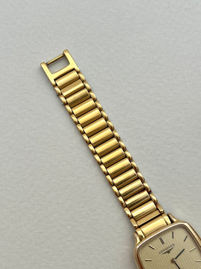 Side profile of the Longines soft-square gold-tone watch case and crown.