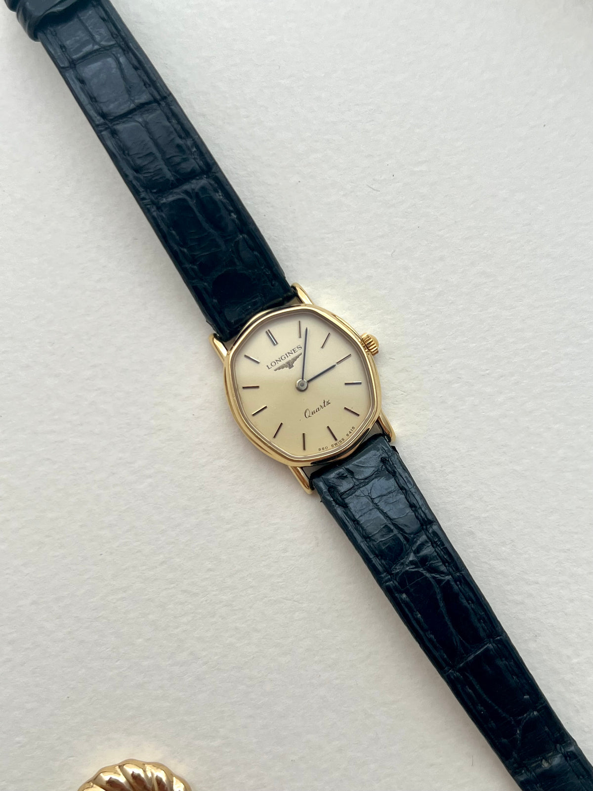 Angled view of the Longines soft tonneau gold-tone case and calm cream dial.