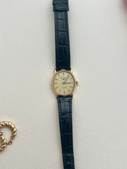 Close-up of the original black croc-embossed Longines leather strap and signed buckle.
