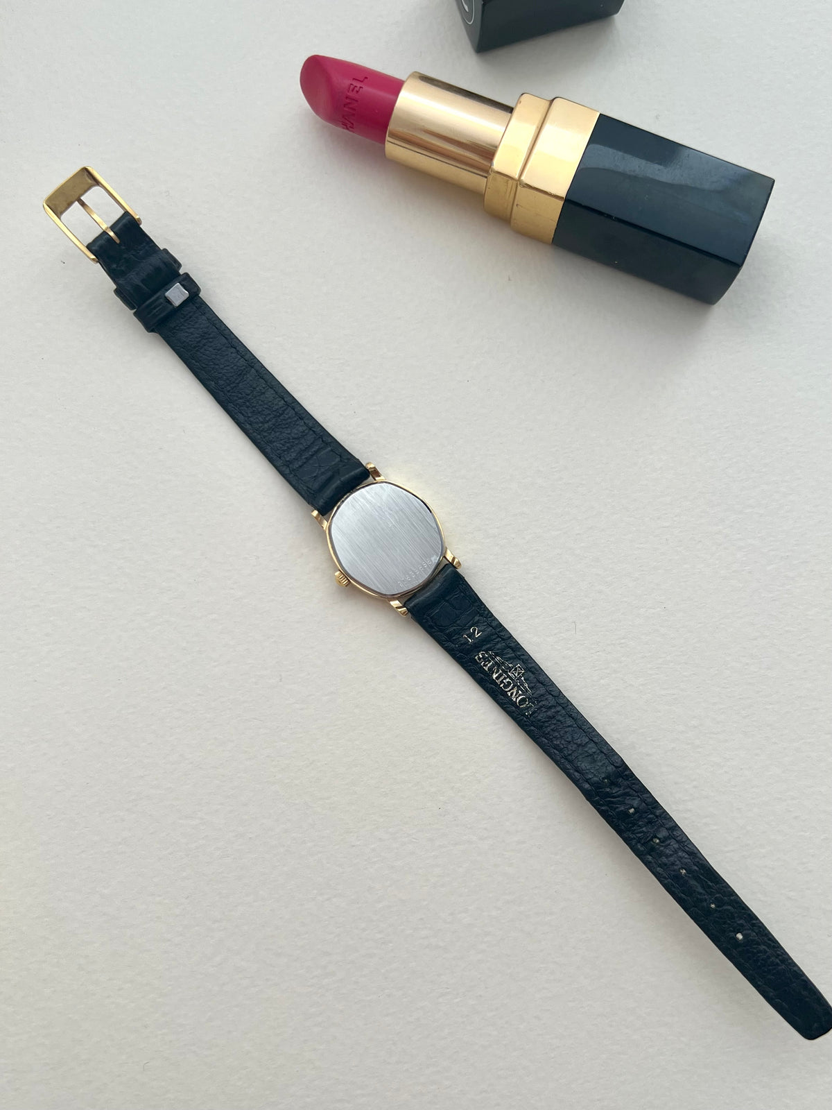 Wrist view of the Longines soft tonneau watch on its original black leather strap.