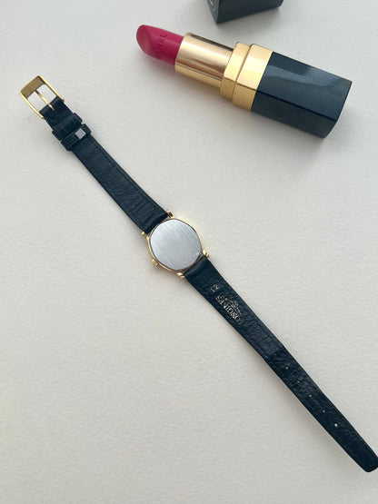 Wrist view of the Longines soft tonneau watch on its original black leather strap.