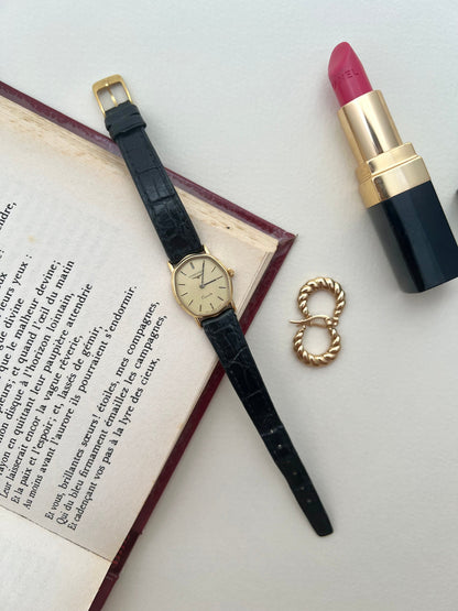 Side profile of the curved Longines soft tonneau case and gold-tone crown.