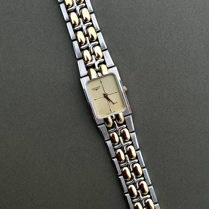 Longines QWR ladies two tone gold and silver bracelet watch with champagne guilloche dial on dark background
