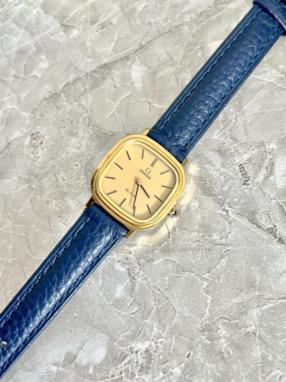 Omega De Ville champagne dial and stepped gold-tone cushion case with navy blue textured strap
