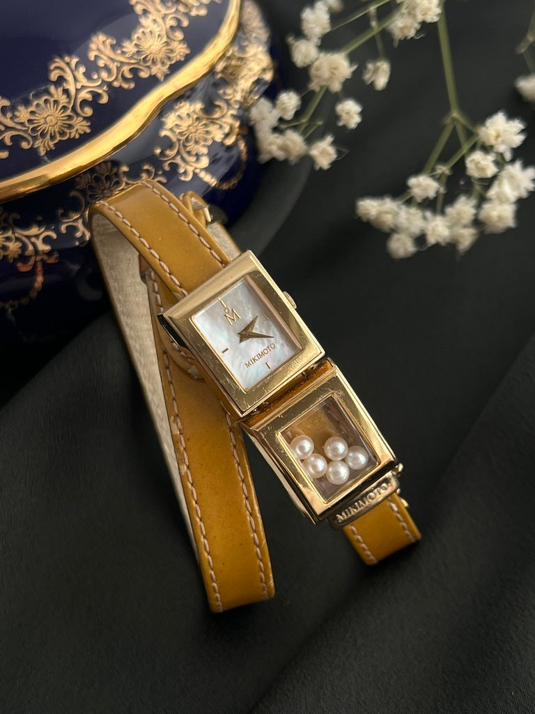 Mikimoto gold-tone moving pearl double-wrap watch with mother-of-pearl dial and tan leather strap