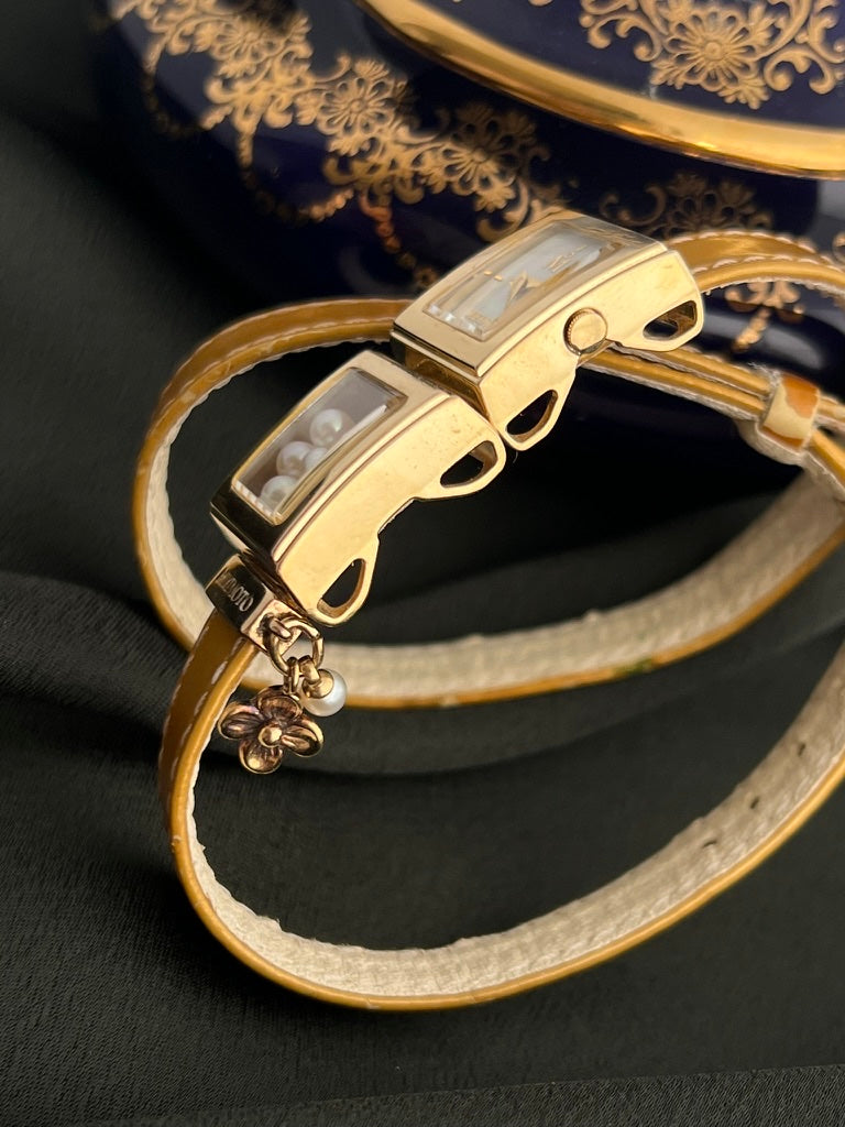 Side profile of Mikimoto multi-form moving pearl watch showing double-wrap leather construction