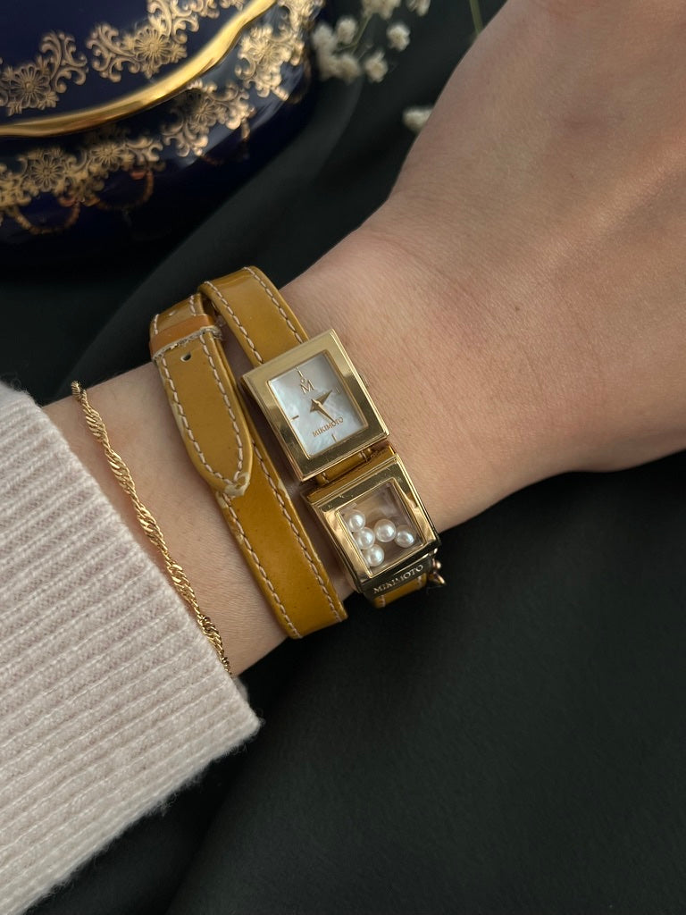 Mikimoto moving pearl double-wrap watch shown worn on the wrist
