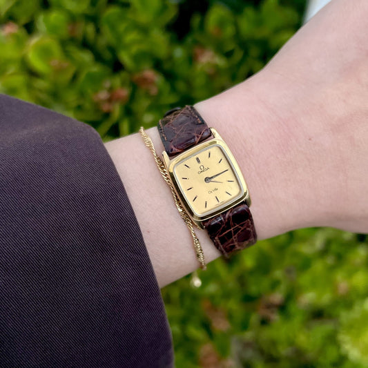Omega De Ville gold cushion watch on wrist with original brown textured strap