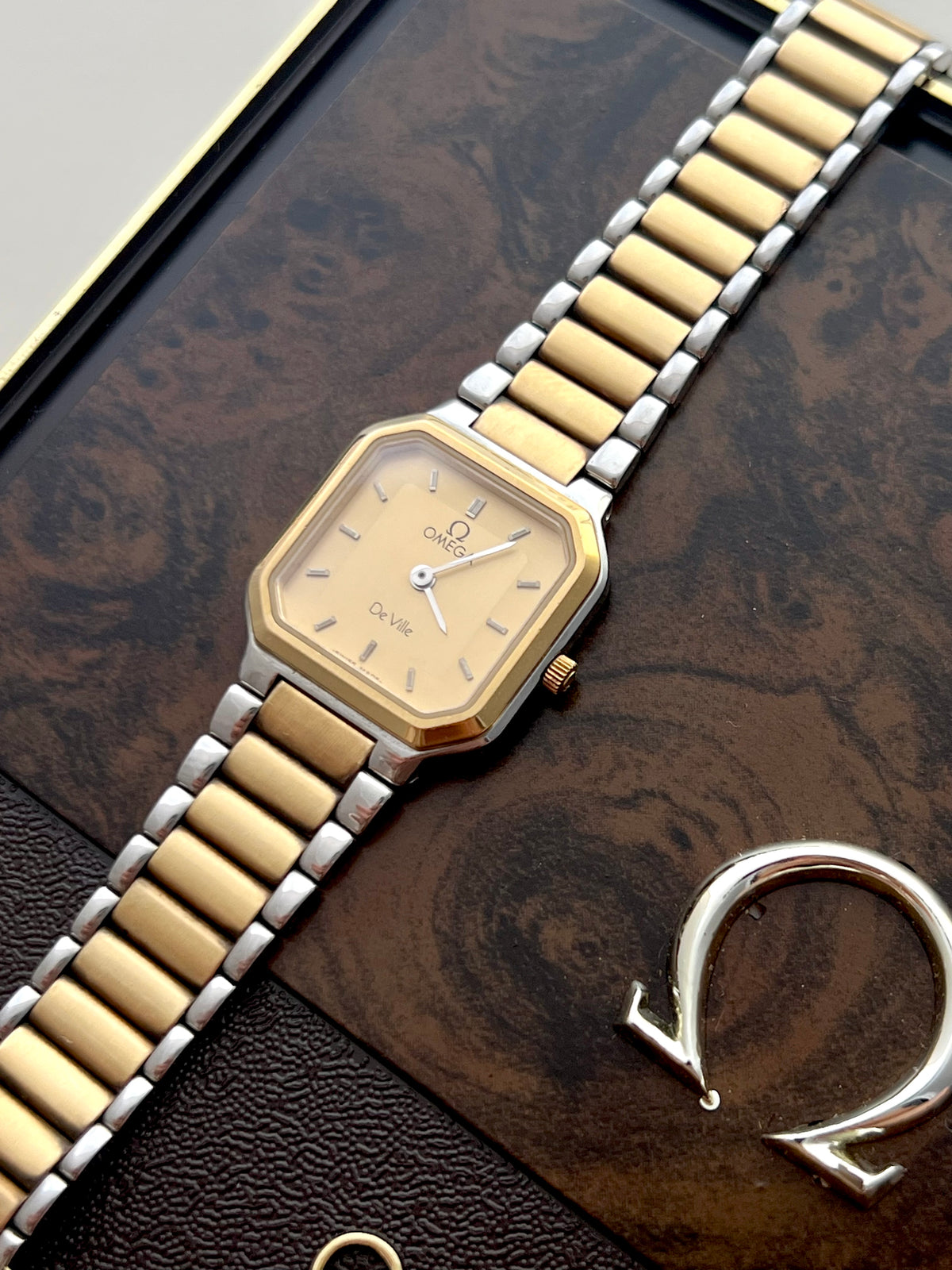Side profile of the Omega De Ville America gold-tone octagonal case and crown.