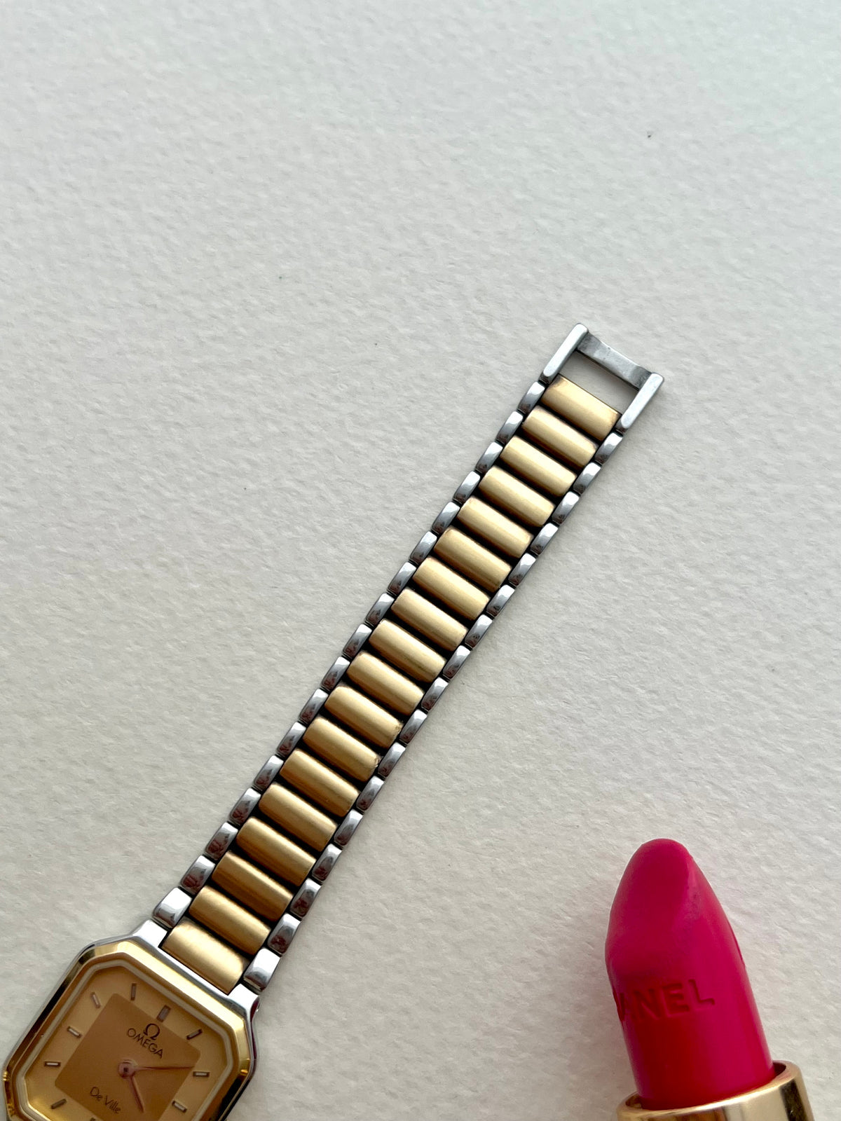 Close-up of the Omega De Ville America gold and steel bracelet links and signed clasp.