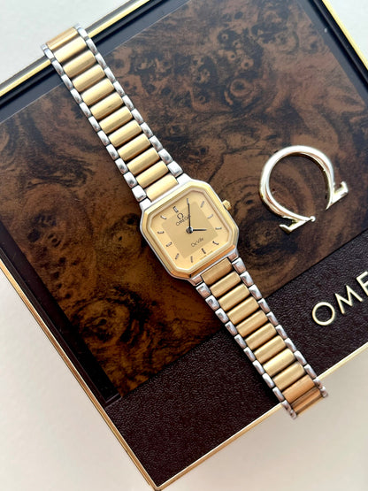 Full view of the Omega De Ville America octagonal watch with champagne dial and two-tone bracelet.
