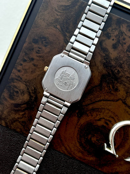 Angled view of the sculpted gold octagonal bezel and two-tone Omega De Ville case.