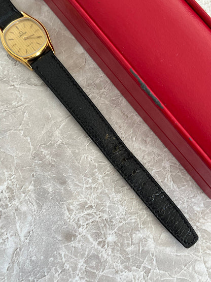 Close-up of the black leather strap attached to an Omega De Ville gold-tone women's cushion watch