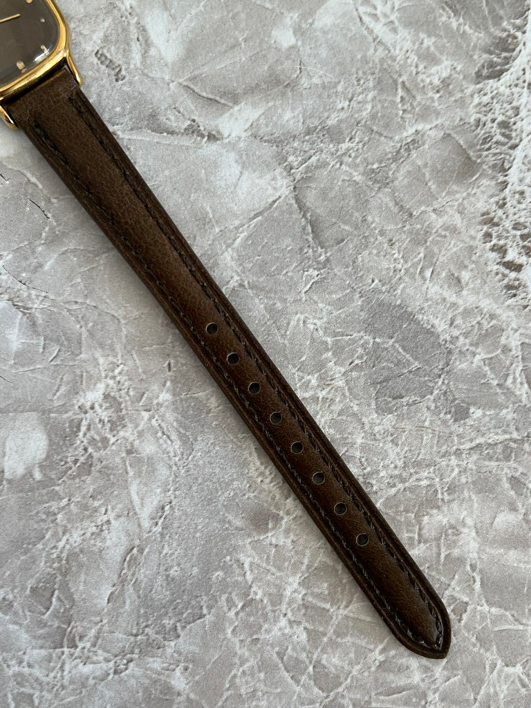 Brown watch strap with adjustment holes on Omega De Ville cushion watch