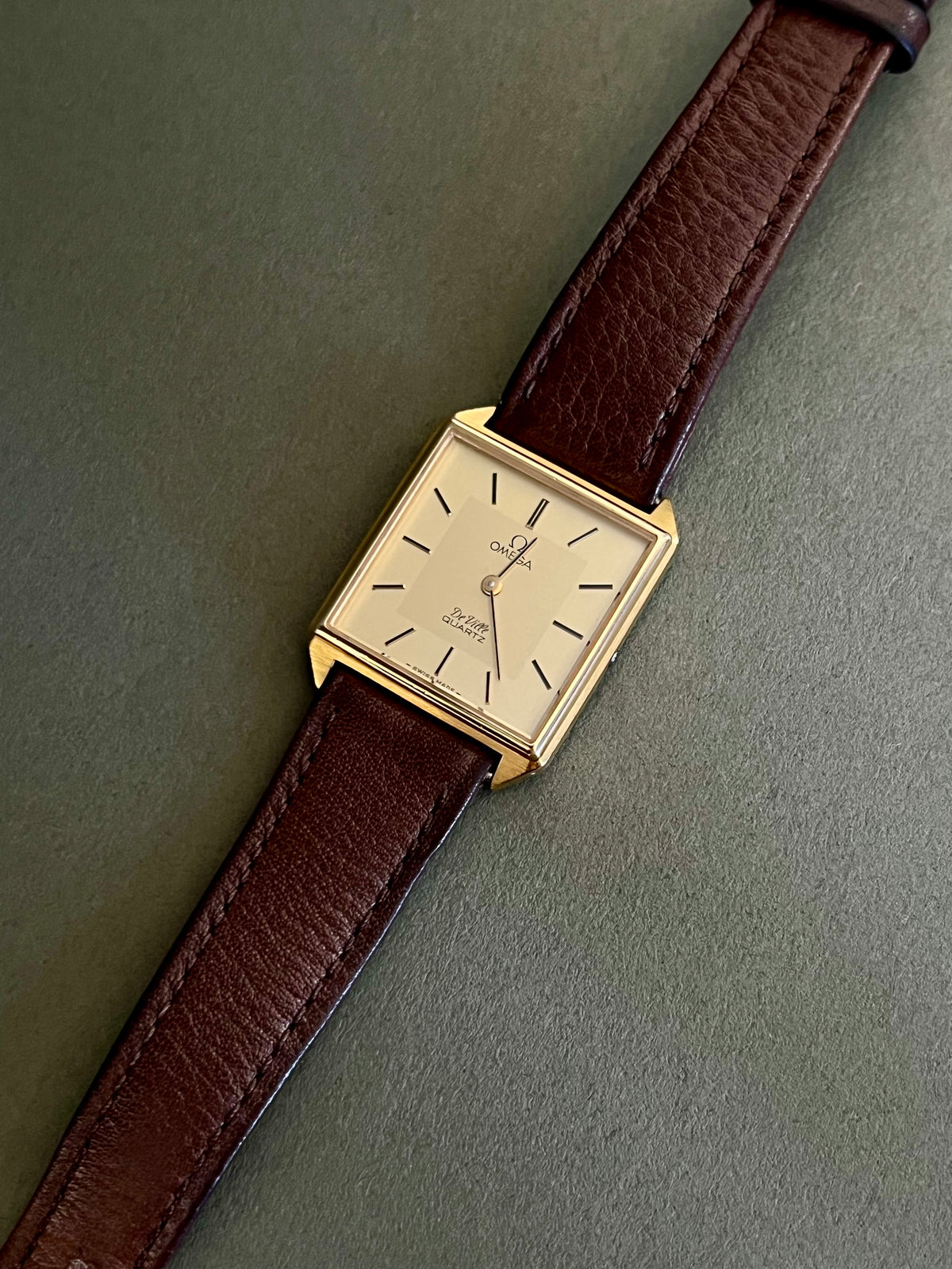 Omega De Ville ladies quartz watch with a double-frame rectangular gold-tone case and champagne dial.