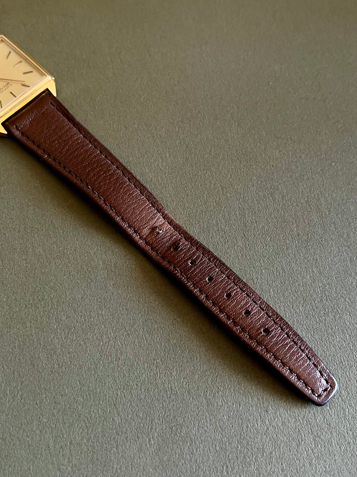 Omega De Ville women's quartz watch with its distinctive rectangular gold-tone case.