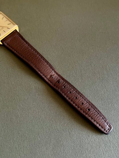 Omega De Ville women's quartz watch with its distinctive rectangular gold-tone case.