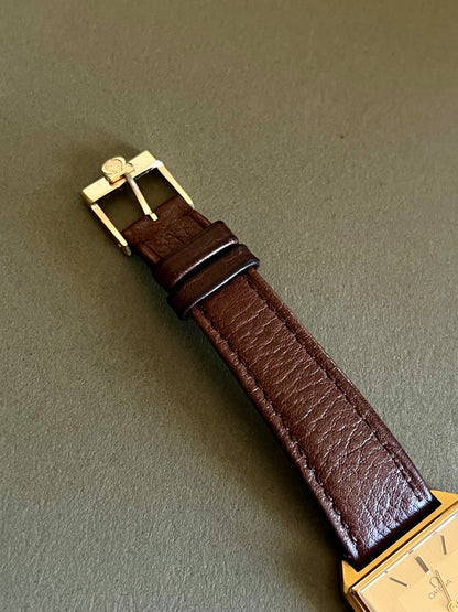 Champagne dial and double-frame rectangular case of the Omega De Ville watch.
