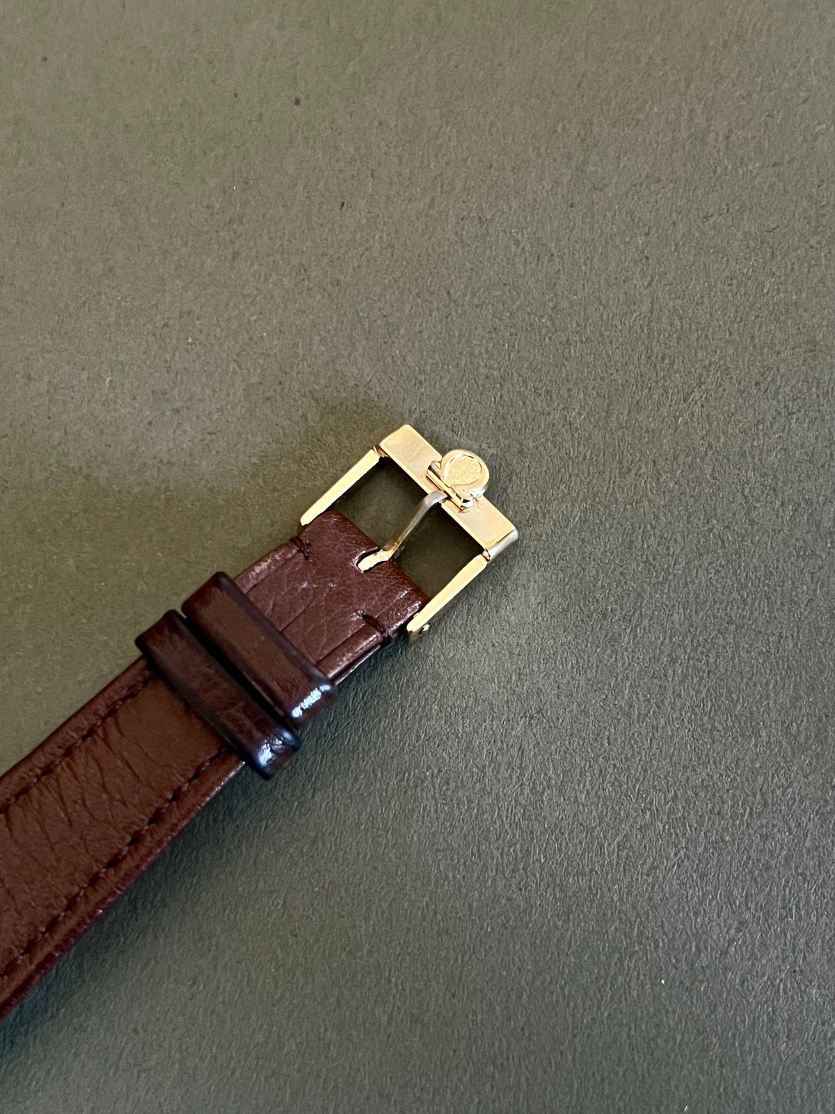 Gold-tone Omega De Ville ladies watch with brown leather strap and understated dial.