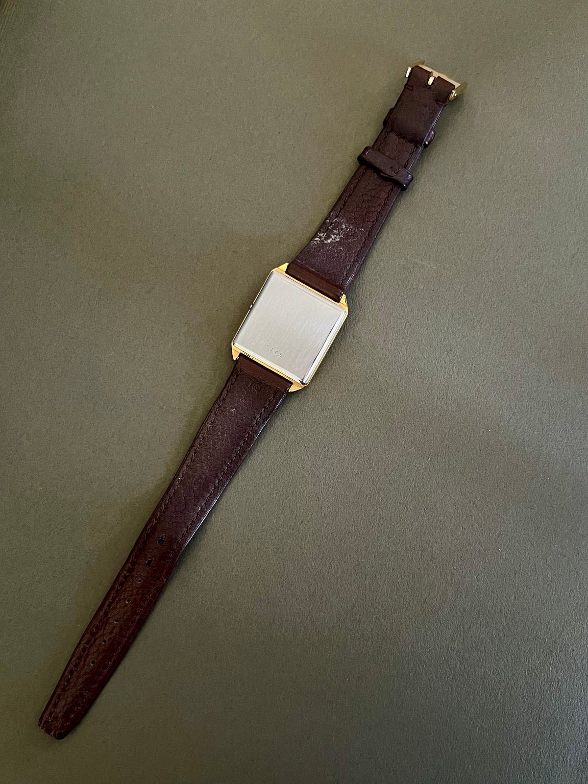 Omega De Ville vintage women's watch with champagne dial and black baton hands.