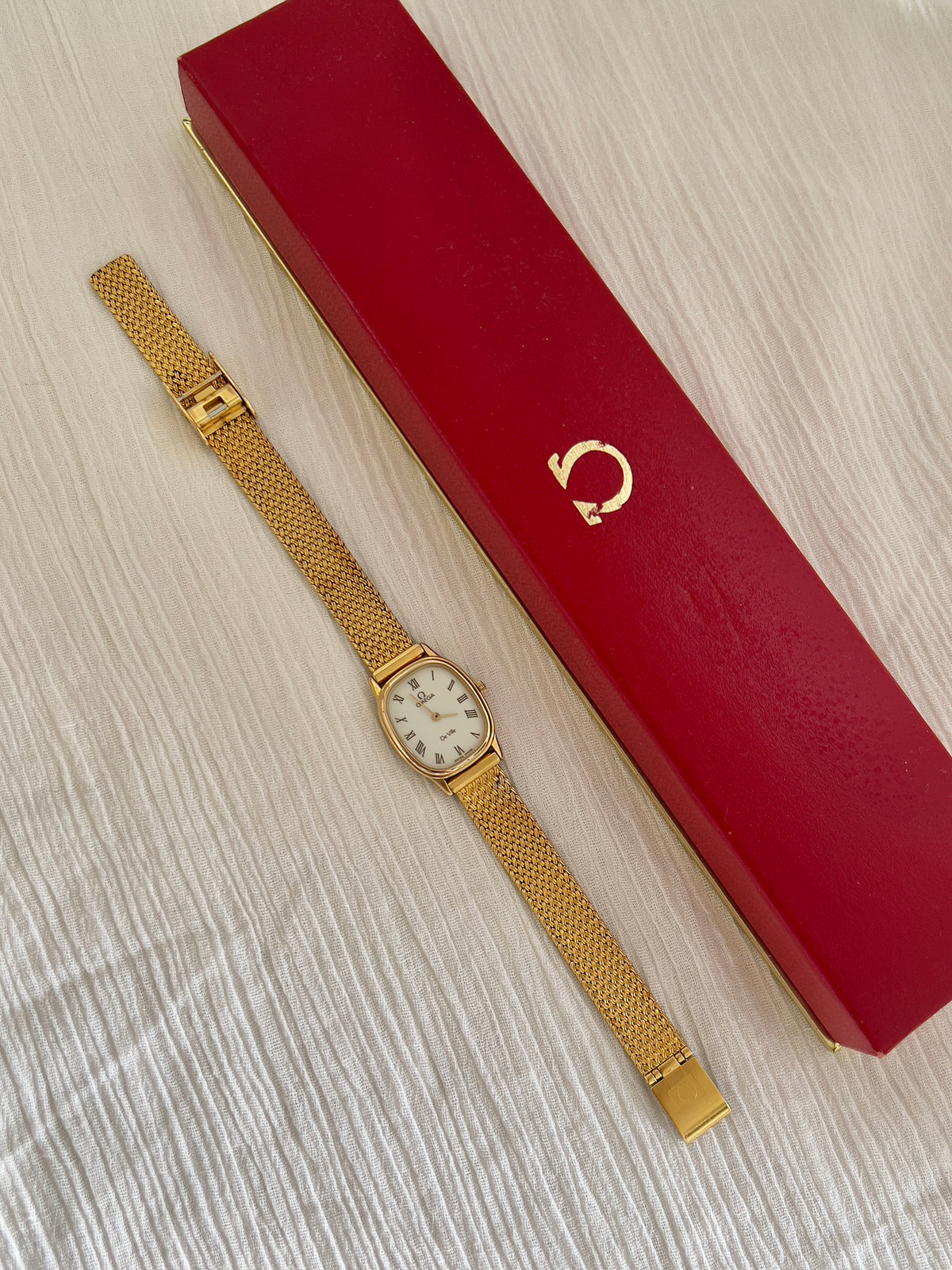Angled view of the Omega De Ville gold mesh watch.