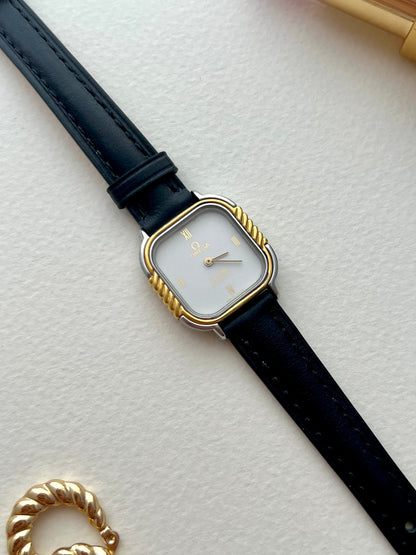 Omega De Ville cushion-case watch with black leather strap shown on the wrist.