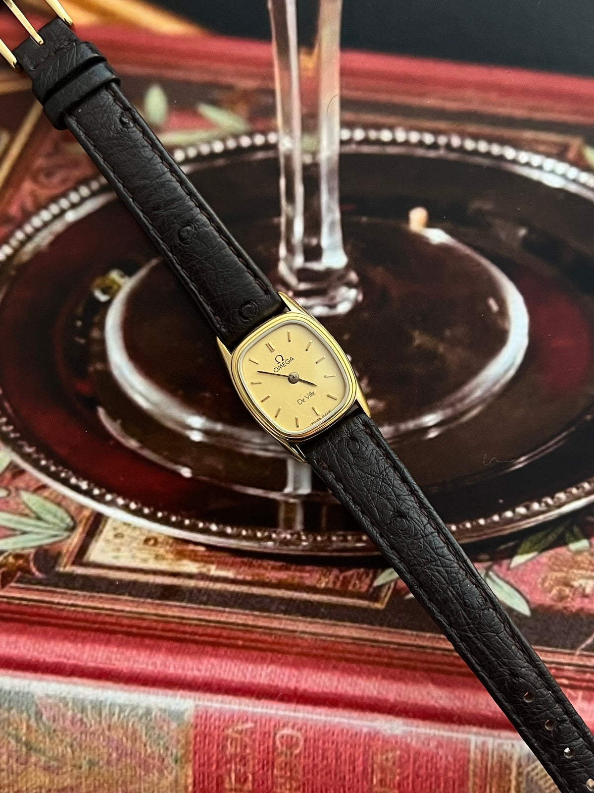 Close-up of the Omega De Ville champagne dial and polished gold-tone hour markers.
