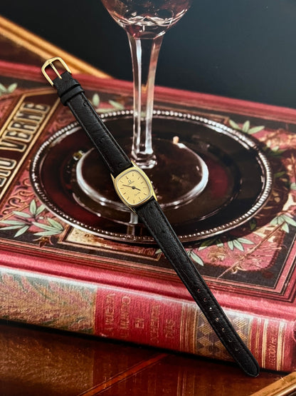 Front view of the small Omega De Ville cushion watch with champagne dial and double-bezel case.