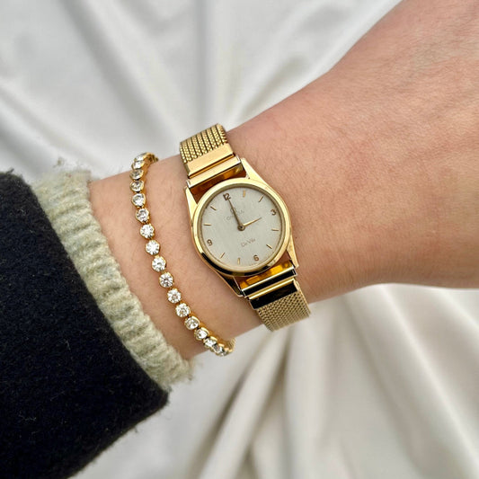 Omega De Ville gold-tone ladies watch with silvered dial and Italian elastic mesh bracelet.