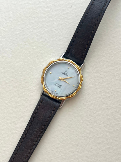 Omega De Ville mother-of-pearl watch displayed with its original red presentation box.