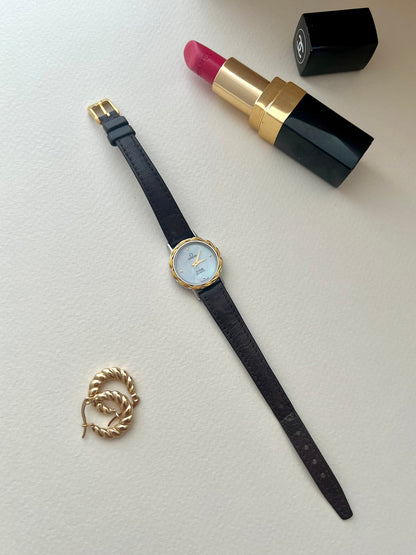Side profile of the Omega De Ville gold-tone case and integrated crown.