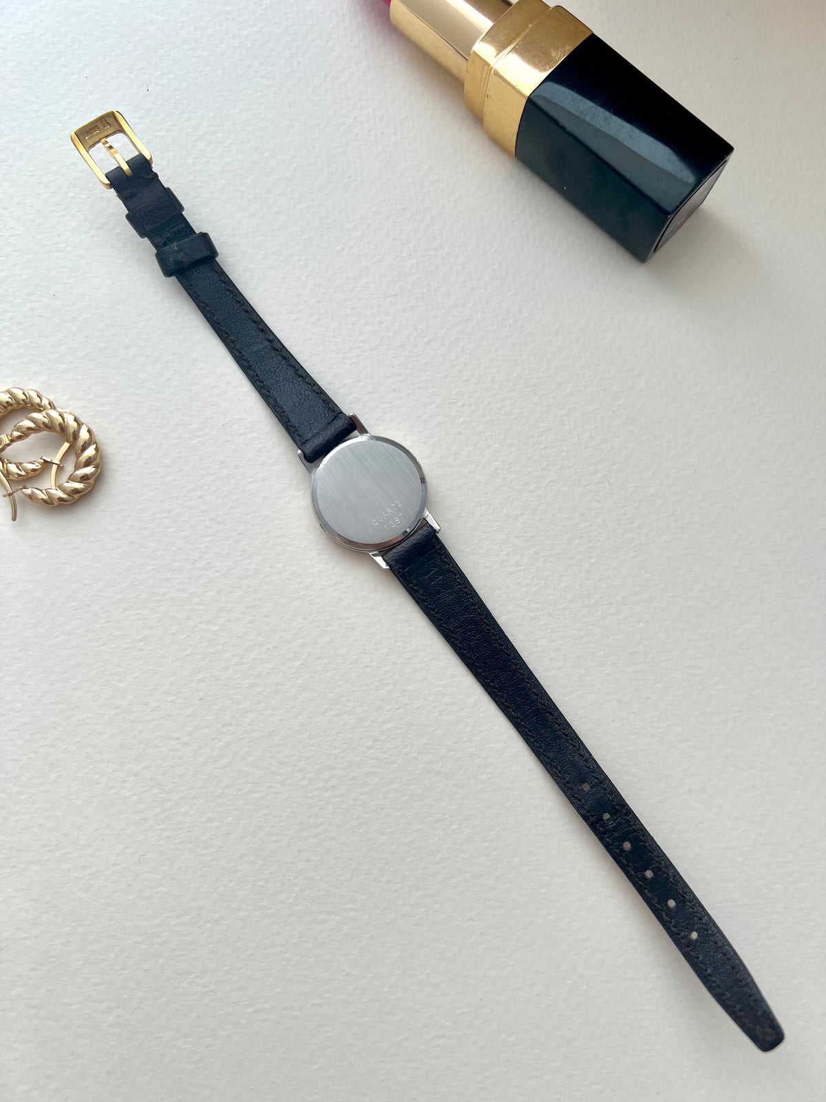 Wrist view of the Omega De Ville mother-of-pearl dial watch on its gold mesh bracelet.