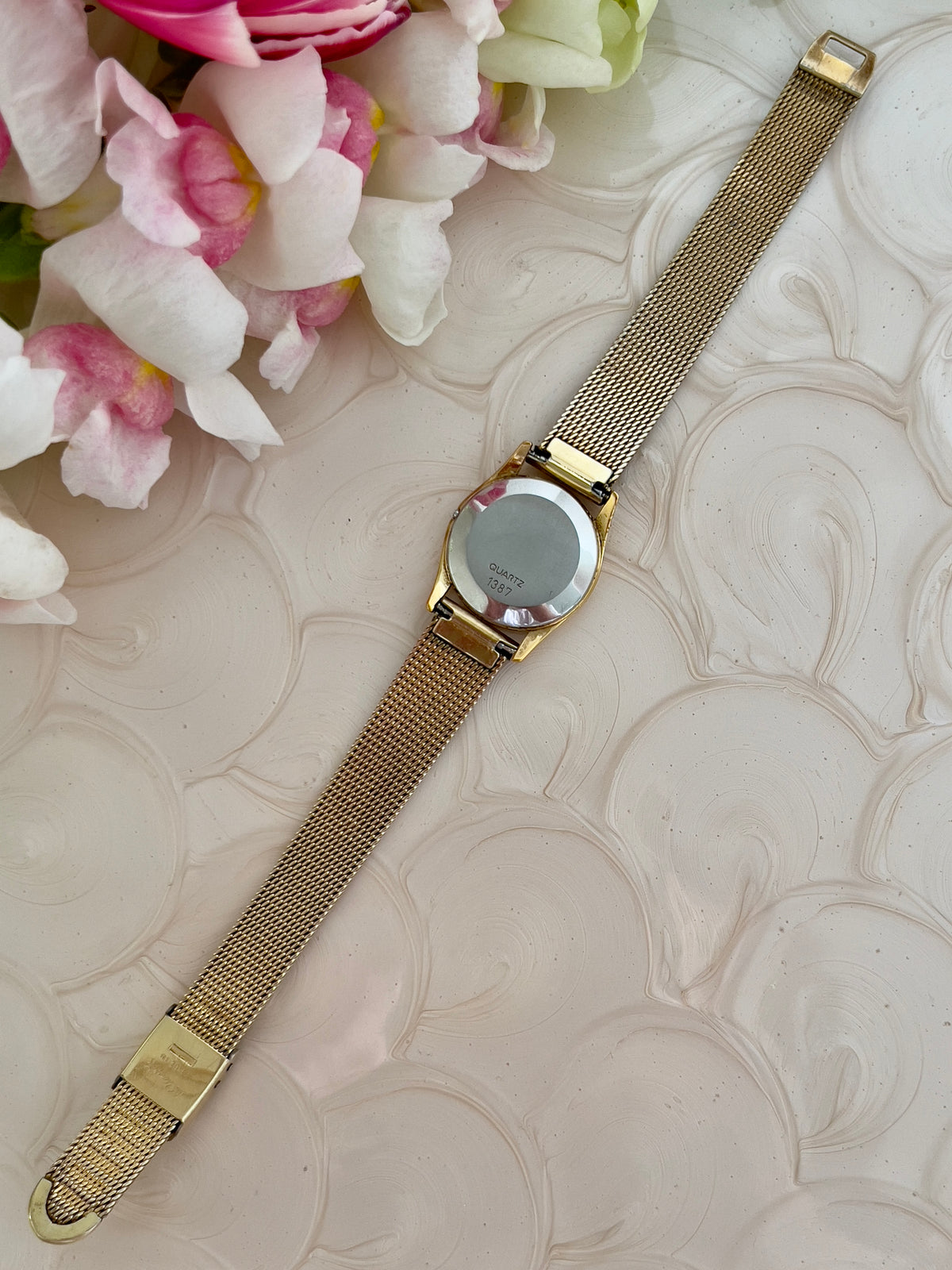 Side profile of the slim gold-tone case on the Omega De Ville watch.