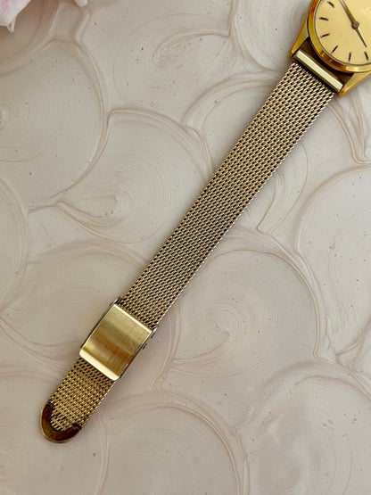 Omega De Ville mesh bracelet watch pictured on a wrist.