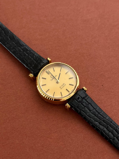 Omega De Ville gold-tone watch displayed with its included box.